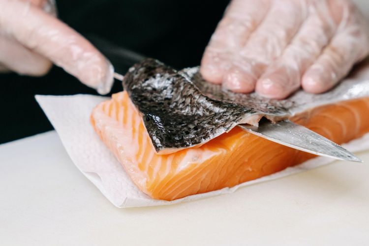 Ilustrasi cara melepaskan kulit salmon dari dagingnya.