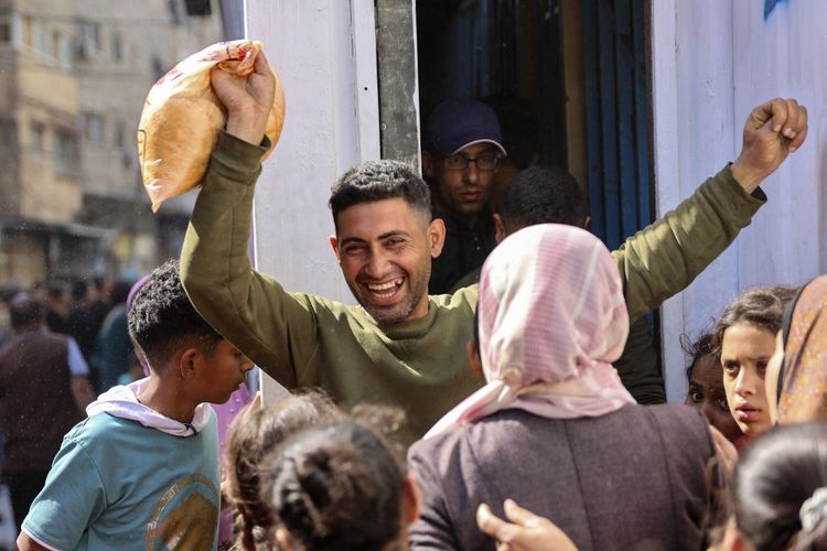 Seorang warga Palestina bereaksi setelah membeli roti bersubsidi di luar sebuah toko roti di Kota Gaza pada 14 April 2024, di tengah konflik yang sedang berlangsung antara Israel dan kelompok militan Hamas. 