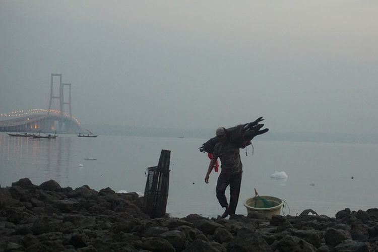 Seorang nelayang yang sedang merapihkan alat penangkap ikan