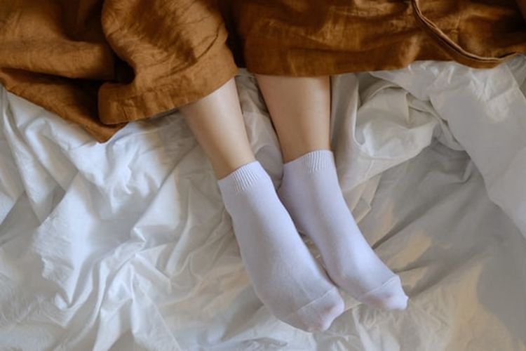 Ilustrasi memakai kaus kaki saat tidur.