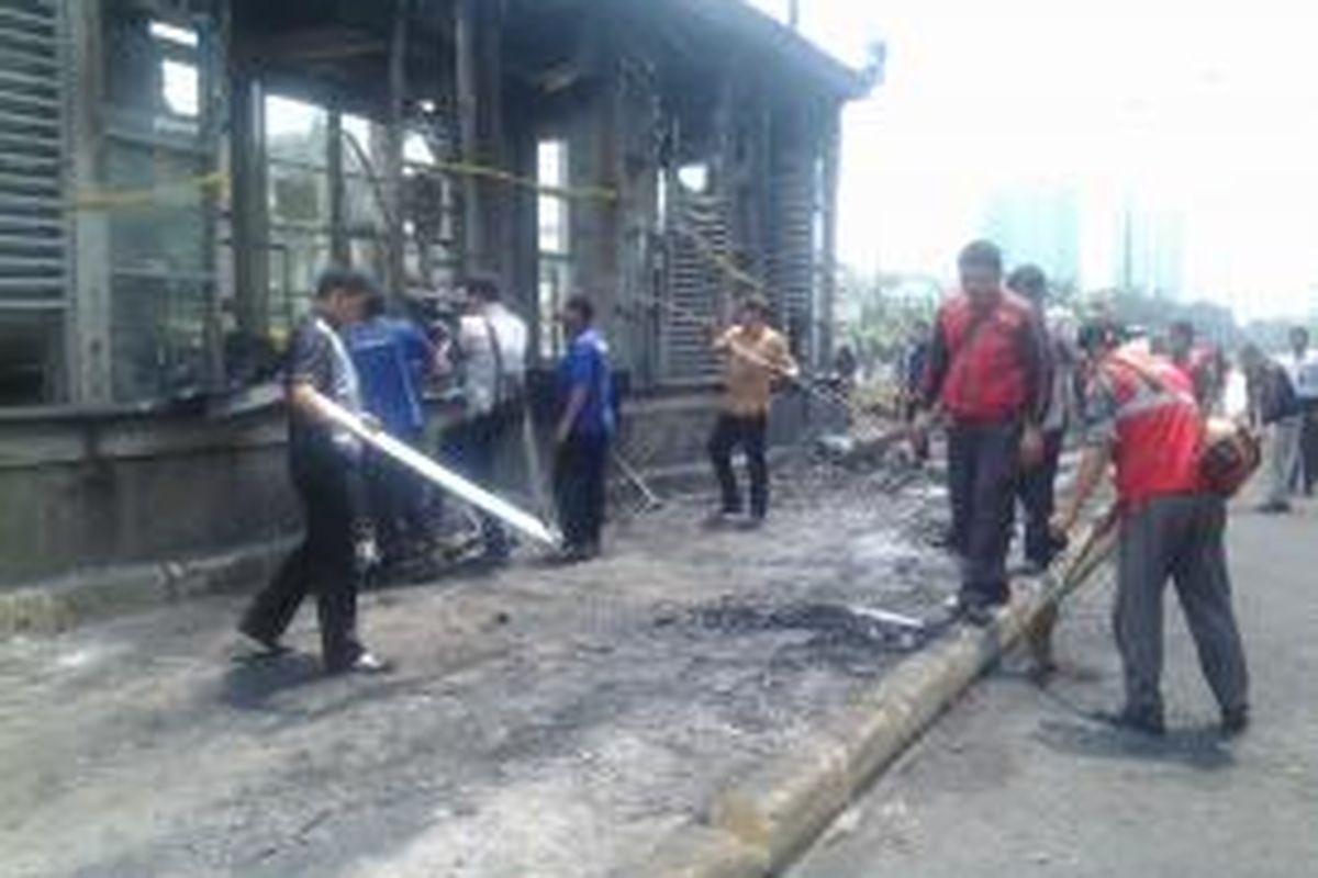 Petugas membersihkan halte bekas kebakaran di Jalan Sisimangaraja, Jakarta Selatan, Kamis (28/8/2014).