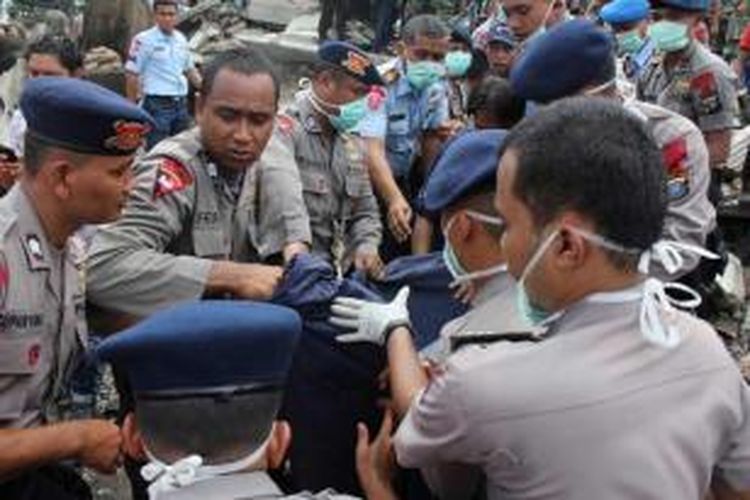 Tim penolong membawa seorang korban jatuhnya pesawat Hercules C-130 TNI AU di Jalan Jamin Ginting, Medan, Sumatera Utara, 30 Juni 2015. Pesawat itu jatuh dua menit setelah lepas landas dari Pangkalan Udara Soewondo pada pukul 12.08 WIB ketika hendak menuju Tanjung Pinang.