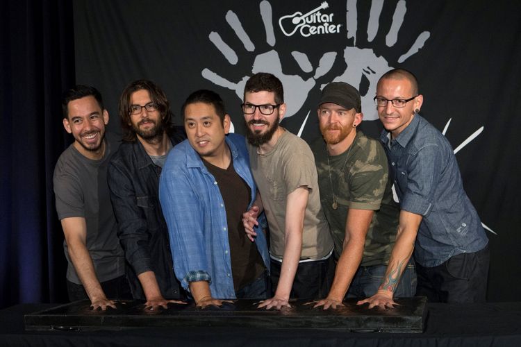Anggota band rock Linkin Park (ki-ka) Mike Shinoda, Rob Bourdon, Joe Hahn, Brad Delson, Dave Farrell dan Chester Bennington meletakkan telapak tangan mereka di semen saat mereka masuk ke Guitar Centers RockWalk di Los Angeles, California, 18 Juni 2014. 