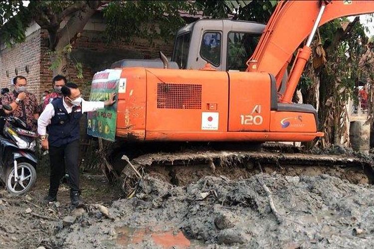 Pj Bupati Bekasi Dani Ramdan saat memantau proses pengerukan lumpur Kali Cikarang.