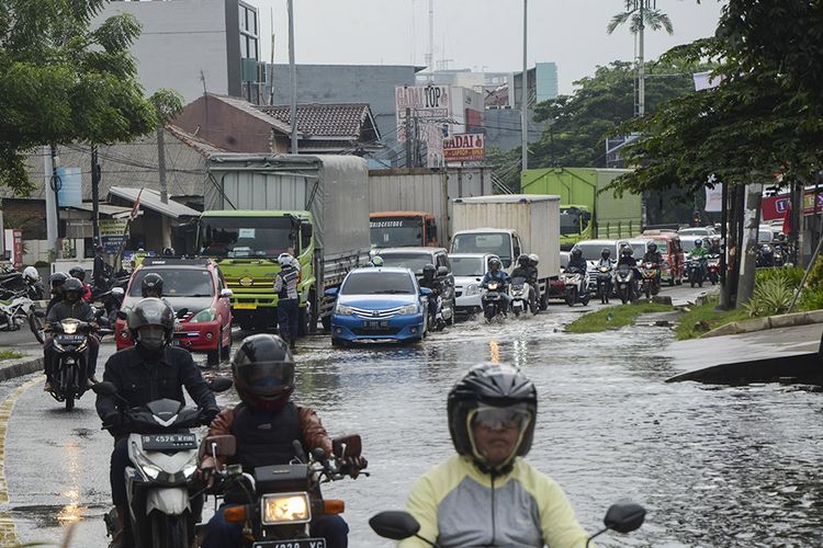 Sejumlah kendaran bermotor terjebak kemacetan akibat jalan Sultan Agung yang tergenang banjir di Bekasi, Jawa Barat, Selasa (21/1/2020). Banjir setinggi 20 cm diakibatkan oleh saluran drainase yang buruk sehingga menyebabkan kemacetan di sejumlah jalan raya Bekasi.