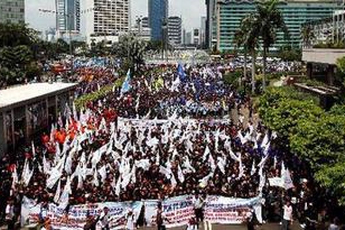 Buruh berunjuk rasa di kawasan Bundaran Hotel Indonesia, Jalan MH Thamrin, Jakarta, Selasa (1/5/2012). Aksi yang dilakukan bertepatan dengan Hari Buruh Internasional ini dikuti oleh ribuan buruh dari wilayah Jabodetabek. Dalam aksinya mereka menuntut pemerintah untuk memperhatikan kesejahteraan buruh hingga memberikan jaminan kesehatan. 