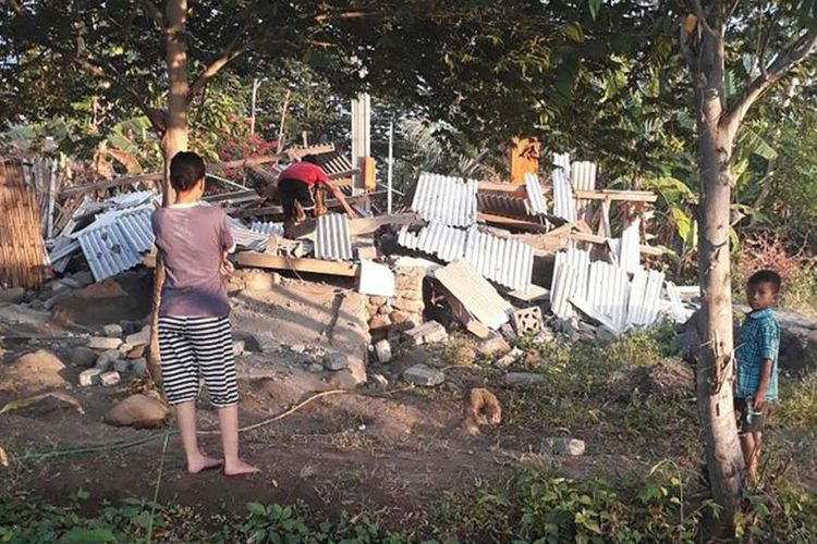 Warga di sekitar reruntuhan bangunan rumah yang rubuh akibat gempa di Lombok, NTB, Minggu (29/7/2018). Berdasarkan informasi dari Badan Meteorologi Klimatologi dan Geofisika (BMKG) gempa pertama kali mengguncang Lombok Timur dengan kekuatan 6,4 skala Richter (SR) pada pukul 06.47 Wita.