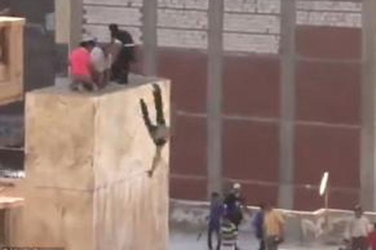 Seorang pemuda dilembar dari atap sebuah bangunan di Aleksanderia, Mesir, kareta tertangkap sedang merayakan tersingkirnya Presiden Muhammad Mursi.