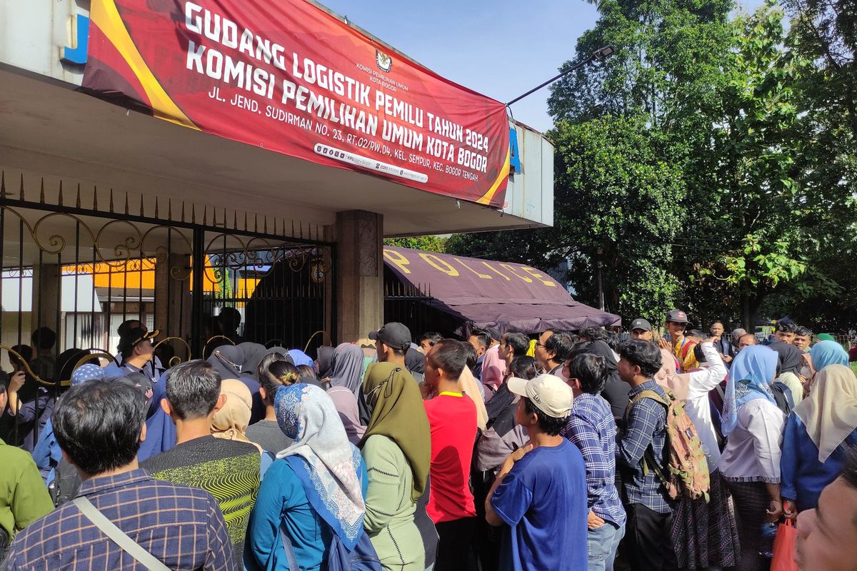 Sejumlah warga mengantre di depan gerbang masuk Gudang Logistik KPU Kota Bogor, Senin (8/1/2024). KPU Kota Bogor, Jawa Barat, mulai melakukan proses penyortiran dan pelipatan surat suara Pemilu 2024 pada hari ini.