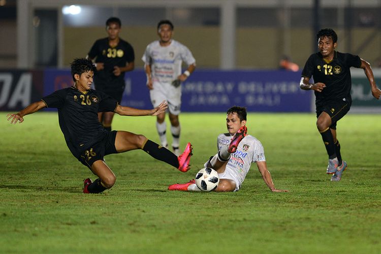 Pesepak bola Tim Nasional (Timnas) U-23 Genta Alparedo (kiri) berebut bola dengan pesepak bola Bali United Arapenta Lingka (kedua kanan) dalam pertandingan uji coba di Stadion Madya, Gelora Bung Karno (GBK), Jakarta, Minggu (7/3/2021). Pertandingan dimenangkan Timnas U-23 dengan skor 3-1.