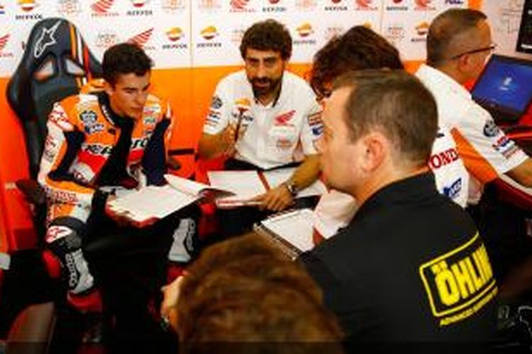 Pebalap Repsol Honda asal Spanyol, Marc Marquez (kiri), berdiskusi dengan tim saat menjalani sesi latihan bebas kedua GP Malaysia di Sirkuit Sepang, Jumat (24/10/2014).