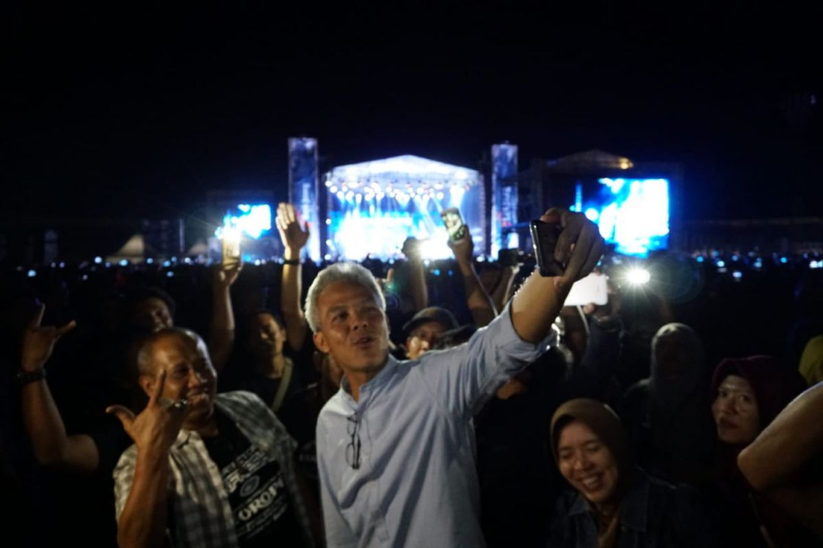 Ganjar Pranowo berswafoto di tengah konser Europe di Boyolali, Jawa Tengah, Sabtu (12/5/2018) malam. 