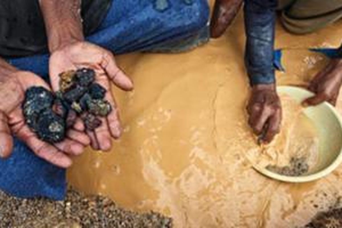 Pekerja menunjukkan batuan yang mengandung timah di tambang PT Timah di Tanjung Pesona, Kecamatan Sungai Liat, Bangka.