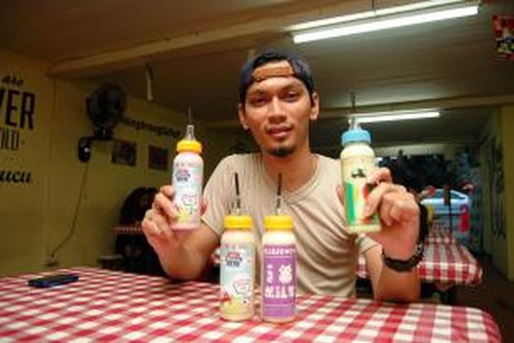 Owner Kedai Mimicucu Bayu Kresnapati menunjukkan minuman susu dengan berbagai rasa di kedai tempat miliknya, Sabtu (14/11/2015).