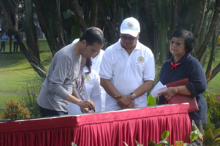 Presiden RI Joko Widodo didampingi Kepala Staf Kepresidenan Teten Masduki dan Menteri Lingkungan Hidup dan Kehutanan Siti Nurbaya Bakar saat menandatangani Prasasti 2 Abad Kebun Raya Bogor, Minggu (11/3/2018).
