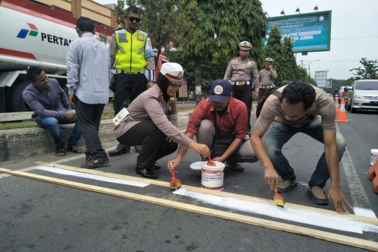 Polisi bersama pengendara yang melanggar aturan lalu lintas mengecat marka jalan di Kota Lhokseumawe, Rabu (4/10/2017)