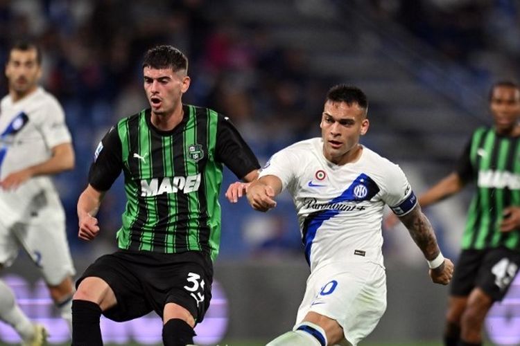 Penyerang Inter Milan, Lautaro Martinez, melepaskan tembakan saat dikawal pemain Sassuolo, Luca Lipani, dalam lanjutan Liga Italia 2023-2024 di Stadion Mapei pada 4 Mei 2024.