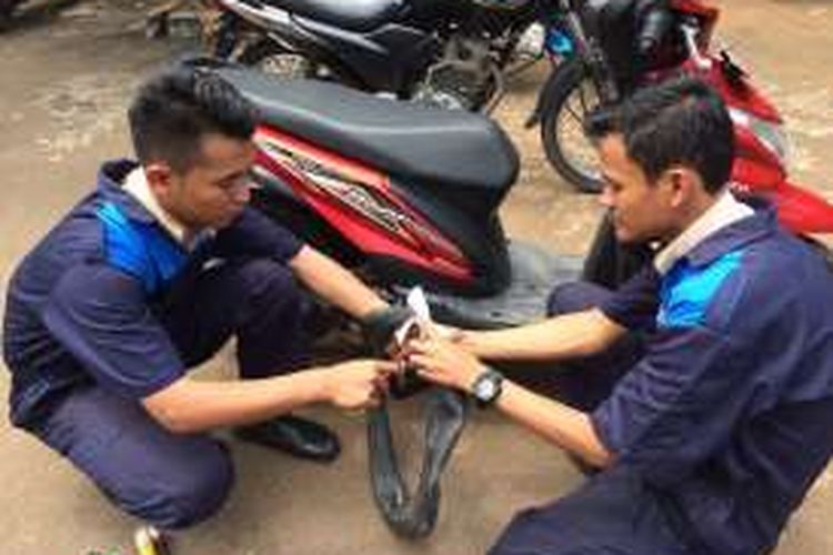 Dua siswa SMK N 1 Kedungwuni, Pekalongan, Jawa Tengah, mempraktekkan cara kerja tambal ban portabel yang menjadi temuannya. 