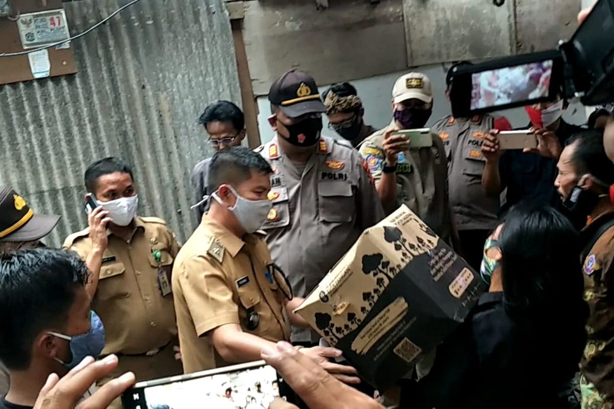 Petugas gabungan yang terdiri dari Polisi, Satpol PP hingga petugas Kelurahan Pluit ikut turun tangan membagikan langsung bantuan sosial kepada warga di RT 02 RW 022, Muara Angke, Pluit, Penjaringan, Jakarta Utara, Selasa (24/11/2020) sore.