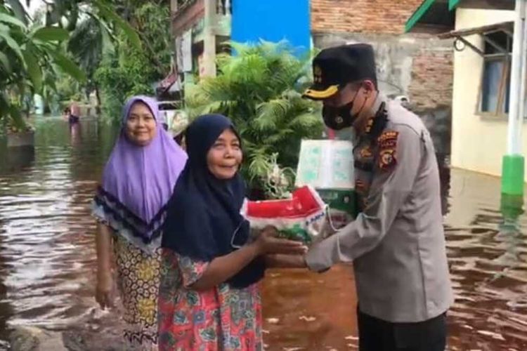 Kapolres Dumai AKBP Mohammad Kholid menyerahkan bantuan beras kepada warga yang terdampak banjir di Kota Dumai, Riau, Kamis (28/10/2021).