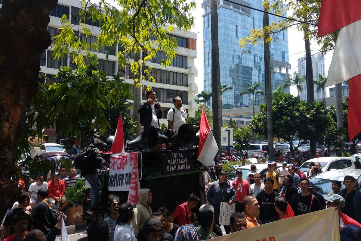 Pengemudi transportasi online yang tergabung di bawah komunitas Gerakan Hantam Aplikasi Nakal (Gerhana) menggelar aksi unjuk rasa di depan Gedung Lippo Kuningan, Jakarta Selatan, Senin (10/9/2018).