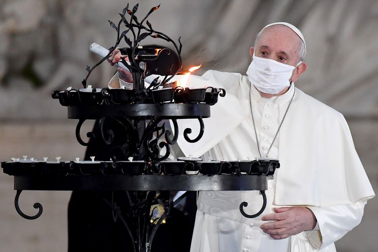 Paus Fransiskus mengenakan masker ketika menyalakan lilin dalam upacara menyerukan perdamaian dihadiri sejumlah pemimpin agama lain di Lapangan Campidoglio di Roma, Italia, pada 20 Oktober 2020.
