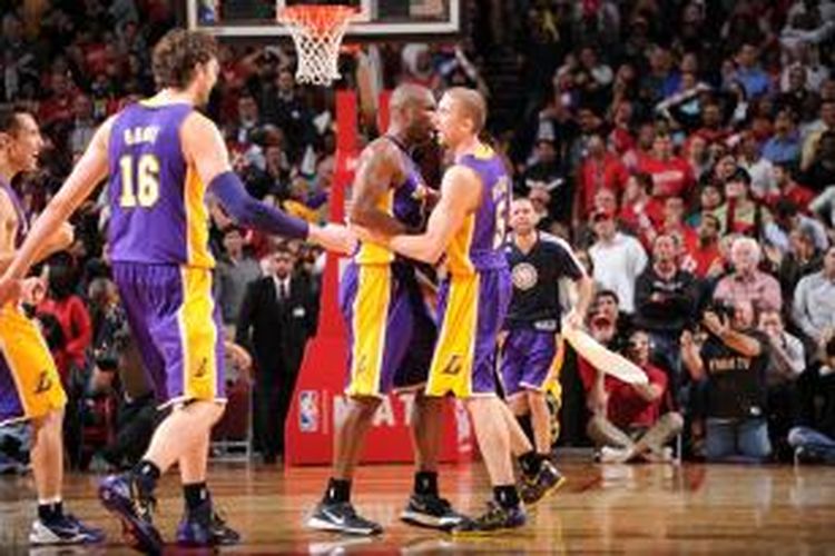 Pebasket Los Angeles Lakers, Steve Blake (5) memeluk rekan satu timnya setelah menyarangkan tembakan tiga angka pada detik akhir pertandingan, yang membawa timnya meraih kemenangan atas Houston Rockets, di Toyota Center, Houston, Kamis (7/11/2013).