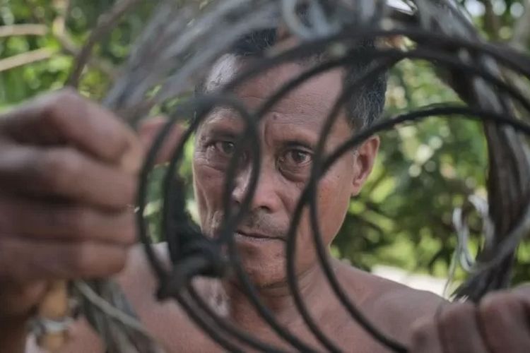 Mawi mengenggam jerat dari sling baja yang digunakan untuk membunuh ratusan harimau Sumatra.