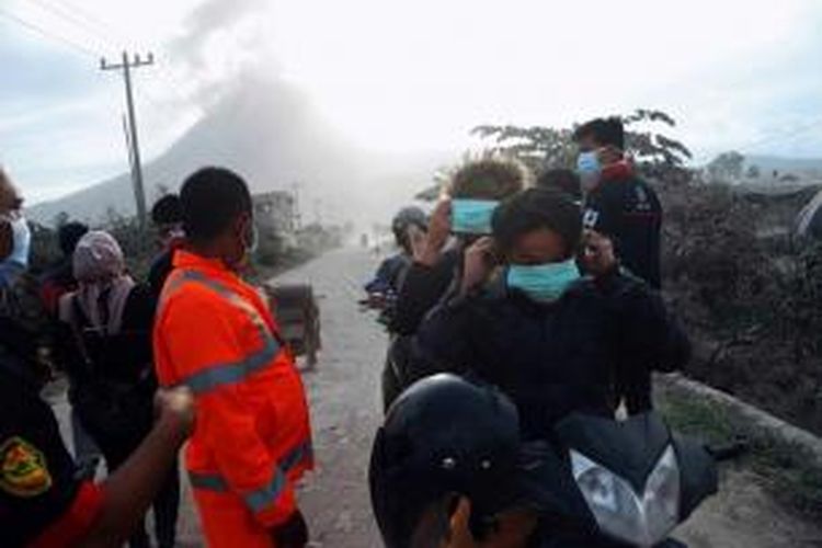 Petugas mendistribusikan masker kepada pengungsi letusan Gunung Sinabung di Karo, Sumatera Utara, Kamis (/10/2014). Letusan gunung ini telah menewaskan 17 orang.