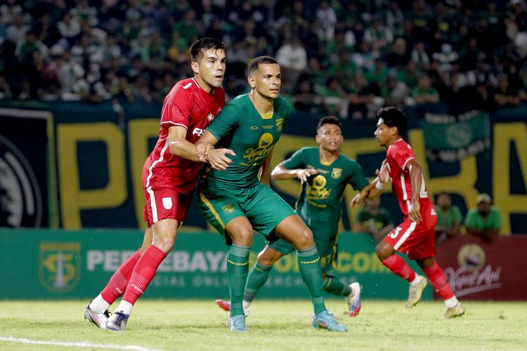 Pemain Persebaya Surabaya Leo lelis dijaga ketat pemain Persis Solo Fabiano Beltrame saat uji coba dalam rangka ulang tahun Kota Surabaya yang ke 729 yang berakhir dengan skor 1-2 di Stadion Gelora Bung Tomo Surabaya, Minggu (22/5/2022) sore.