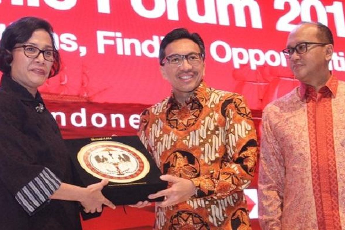 Presiden Direktur CIMB Niaga Tigor M Siahaan (tengah) menyerahkan cenderamata kepada Menteri Keuangan Republik Indonesia Sri Mulyani Indrawati disaksikan Ketua Umum Kadin Indonesia Rosan P Roslani (kanan) di acara CIMB Niaga Economic Forum 2017 di Jakarta, Kamis (26/1). 