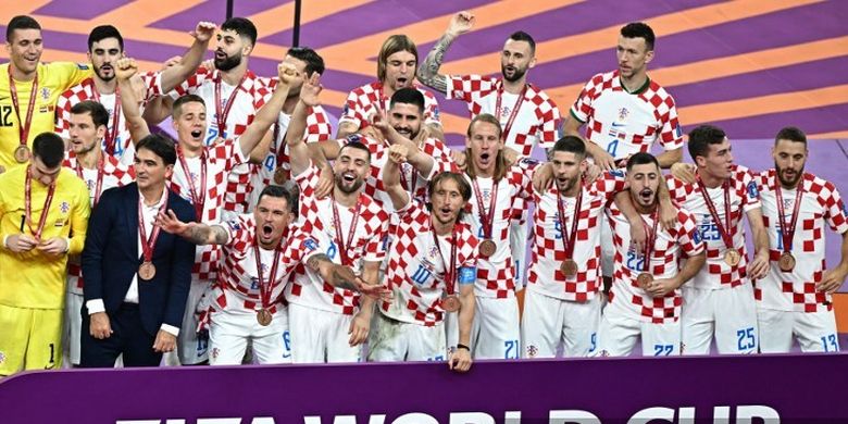 Para pemain dan pelatih Kroasia saat merayakan keberhasilan merebut peringkat ketiga Piala Dunia 2022. Kroasia meraih posisi ketiga seusai menang atas Maroko. Laga Kroasia vs Maroko yang berakhir 2-1 untuk kemenangan Vatreni sudah rampung bergulir di Stadion Internasional Khalifa pada Sabtu (17/12/2022). (Photo by Anne-Christine POUJOULAT / AFP)