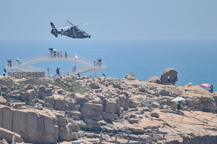 Helikopter militer China melintas di pulau Pingtan dan disaksikan para turis pada Kamis (4/8/2022). Pulau Pingtan adalah wilayah China yang terdekat dengan Taiwan. China menggelar latihan militer setelah kunjungan Ketua DPR AS Nancy Pelosi ke Taiwan.