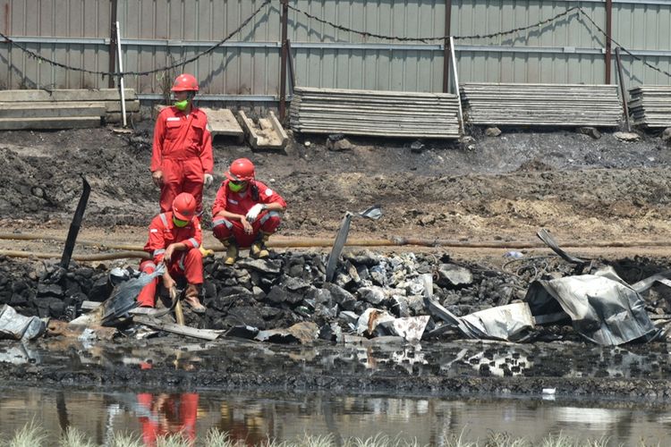 Pasca kebakaran pipa, petugas pertamina mensterilisasi ceceran minyak yang menggenang di persawahan warga, Rabu (23/10/2019).