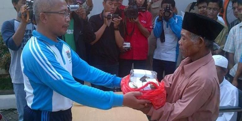 Walang bin Kilon (kanan), 54 tahun, menerima kembali uang yang dibawanya saat mengemis di Jakarta, Selasa (3/12/2013). Penyerahan dilakukan di Panti Sosial Bina Insan Bangun Daya II, Cipayung, Jakarta Timur, Selasa (3/12/2013), sebelum Walang dipulangkan ke Subang, Jawa Barat.