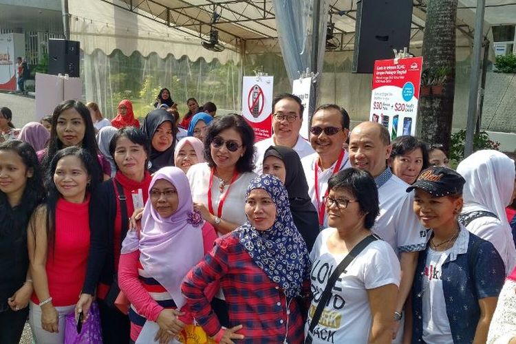 Duta besar Indonesia untuk Singapura, Ngurah Swajaya (tengah, berkaca mata hitam) berfoto bersama para pekerja rumah tangga Indonesia yang datang ke KBRI Singapura, Minggu (26/3/2017).