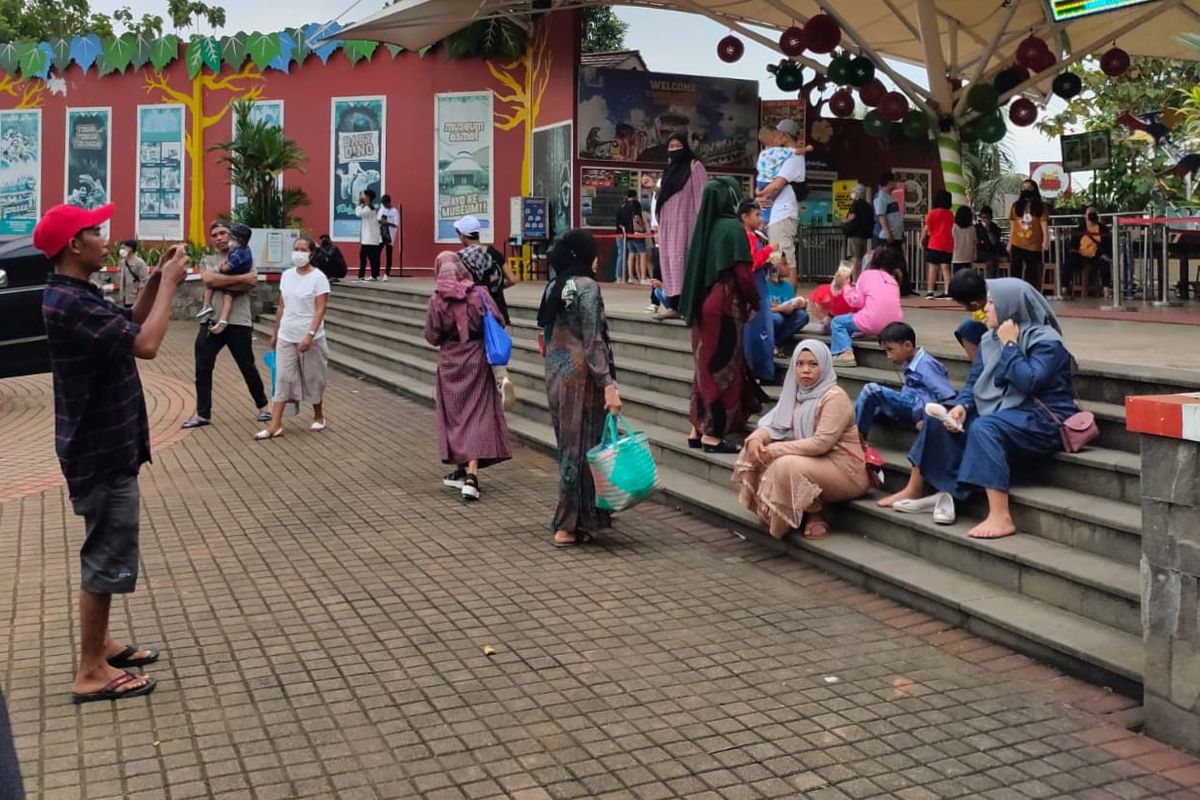 Sejumlah pengunjung yang datang dan berfoto-foto di Taman Mini Indonesia Indah (TMII) untuk menikmati suasana H+1 Libur Lebaran 2022.