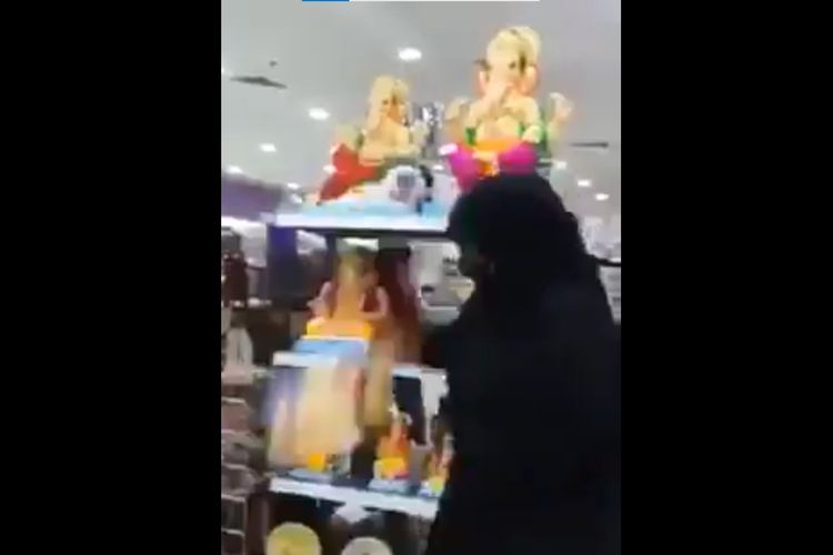 Tangkapan layar dari video yang menampilkan seorang wanita membanting pajangan Dewa Ganesha sampai hancur di toko.