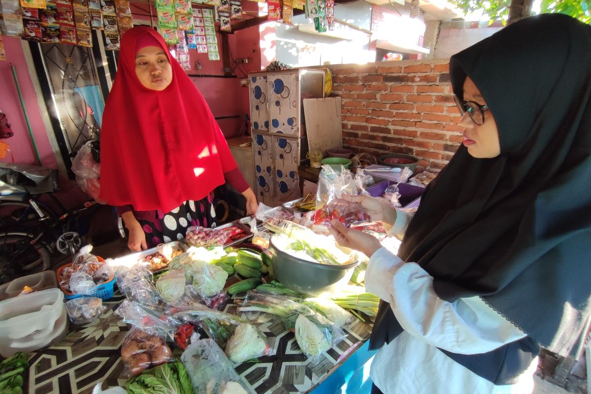 Try Lestari sedang melakukan transaksi pembelian cabai, bawang, dan sayur sayuran, di warung Leli, Perum Taman Pelangi Desa Kejuden Kecamatan Depok Kabupaten Cirebon, Jawa Barat, Jumat (10/6/2022)