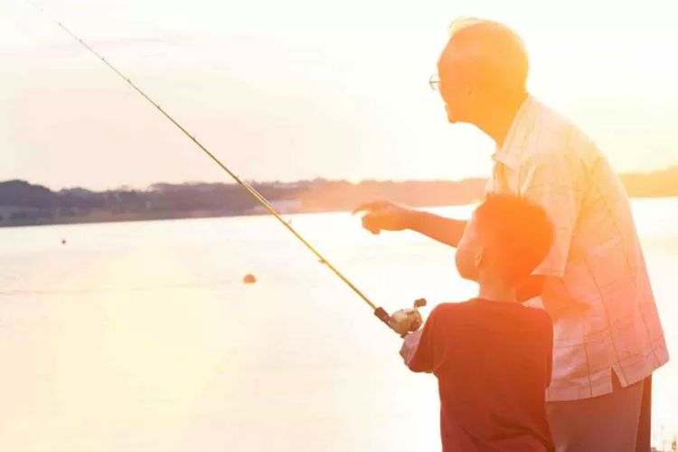 Seorang anak laki-laki memancing ikan bersama kakeknya.