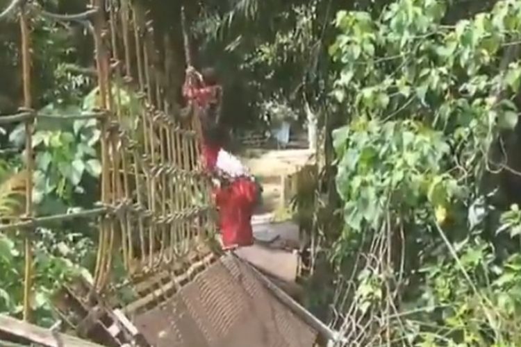 Tangkapan layar siswa sekolah dasar di Desa Aurduri, Kecamatan Nalo Tantan, Kabupaten Merangin saat bergelantungan di jembatan gantung yang rusak untuk berangkat ke sekolah selama enam bulan terakhir