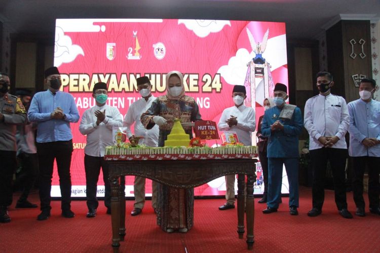 Bupati Tulang Bawang Winarti memotong tumpeng dalam acara HUT Ke-24 Kabupaten Tulang Bawang di Gedung DPRD Tulang Bawang pada Sabtu, (20/3/2021).