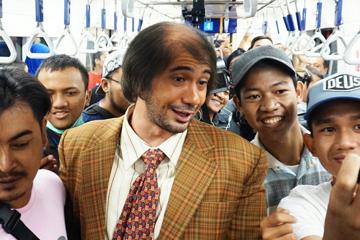 Artis peran Reza Rahadian yang berdandan ala Bossman di My Stupid Boss 2 berswafoto dengan penumpang MRT di MRT Jakarta rute Bundaran HI-Lebak Bulus, Jumat (29/3/2019).