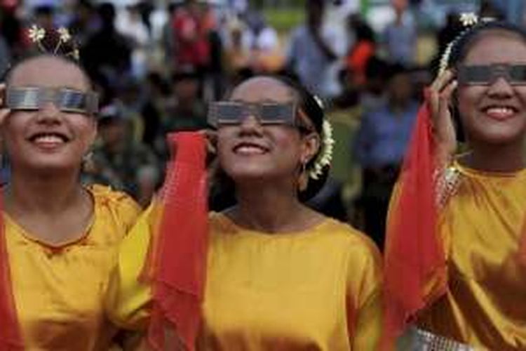 Remaja putri mengamati prosesi gerhana matahari total menggunakan kacamata gerhana di Pantai Soagimalaha di Maba, Halmahera Timur, Rabu (9/3/2016).