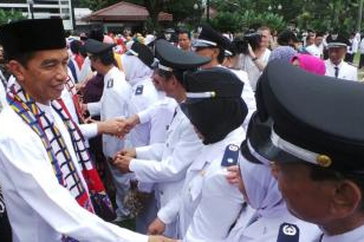 Gubernur Jakarta Joko Widodo bersalaman dengan sejumlah pegawai negeri sipil yang usai dilantik pada beragam jabatan di Balaikota, Jakarta, Jumat (21/3/2014).