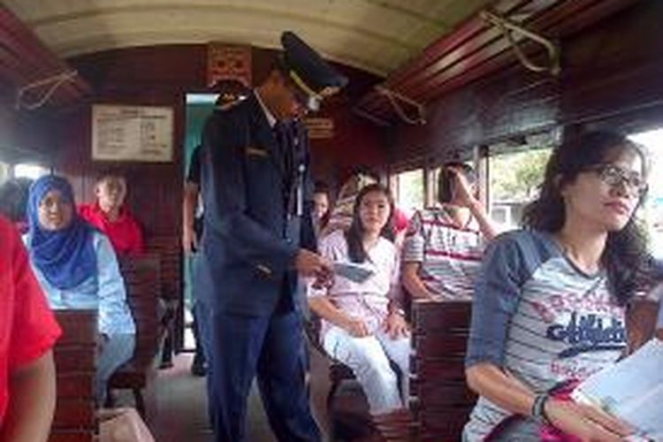 seorang petugas memeriksa tiket penumpang paket wisata perjalanan kereta api dari Stasiun Ambarawa menuju Stasiun Tuntang. 