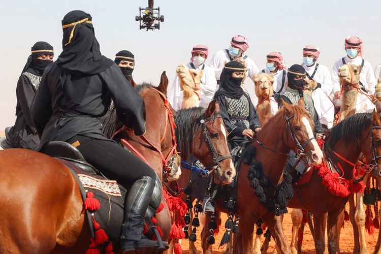 Penunggang unta dan penunggang kuda Saudi ambil bagian dalam parade selama Festival Unta Raja Abdulaziz edisi keenam di wilayah Rumah, timur ibukota Riyadh, Sabtu (8/1/2022). 