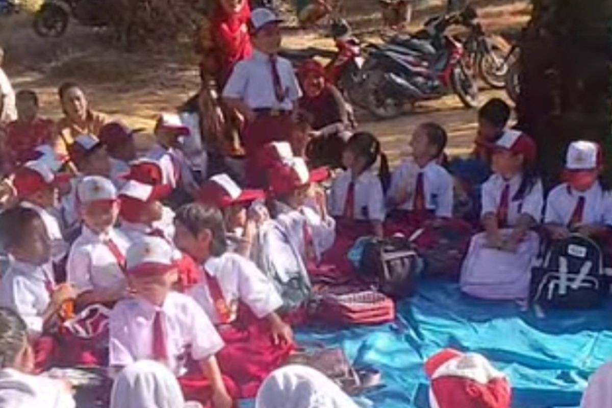 Tangkapan layar video anak-anak baru masuk SD belajar di tanah beratapkan terpal di dalam kebun sawit di kawasan TNTN, Kabupaten Pelalawan, Riau, Senin (14/7/2025).