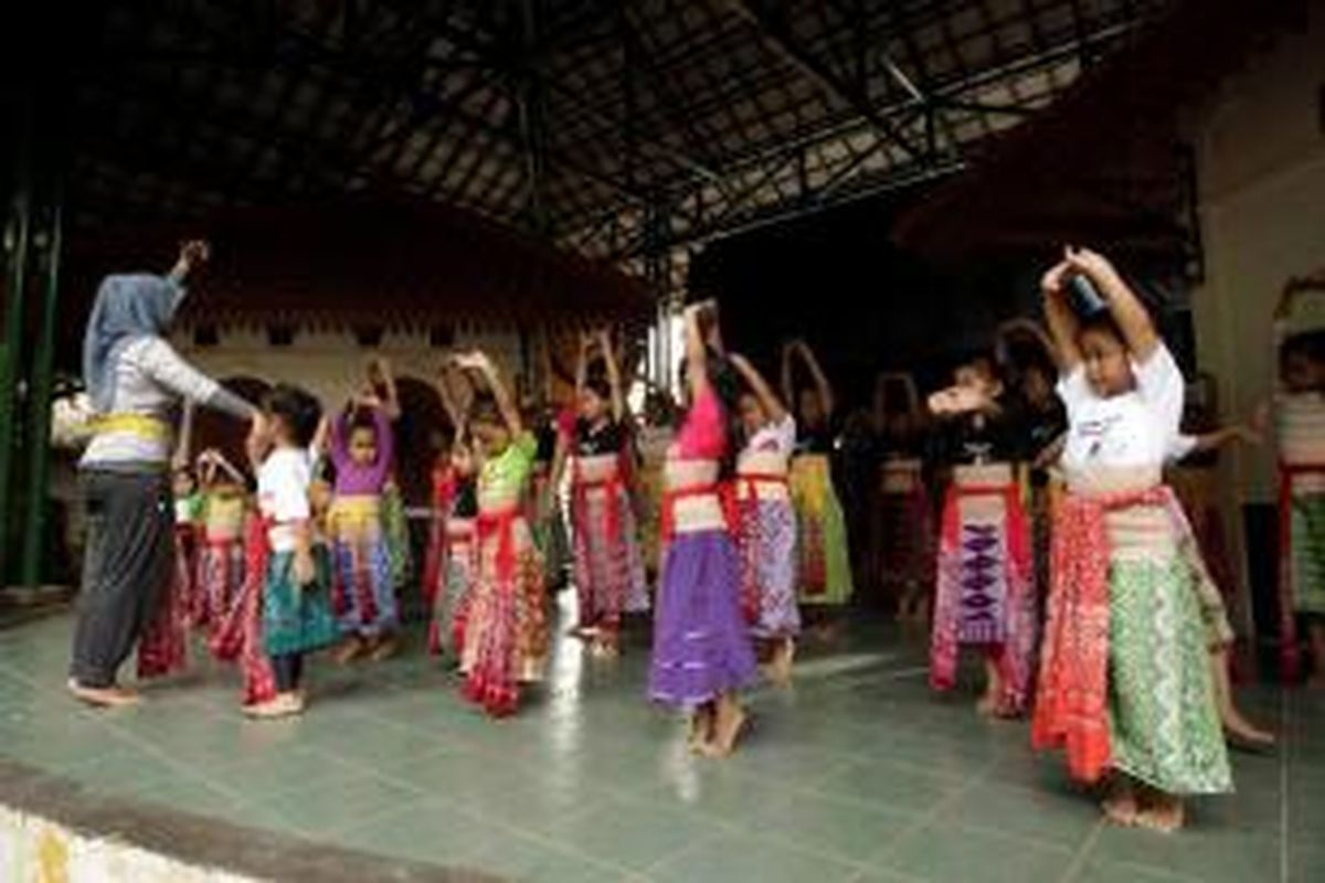 Anak-anak melakukan pemanasan sebelum berlatih menari di sanggar tari di Kampung Betawi Situ Babakan, Jagakarsa, Jakarta Selatan, Rabu (12/6/2013). Kampung Situ Babakan merupakan salah satu kampung betawi yang masih bertahan di Jakarta. Di kawasan yang juga menjadi obyek wisata budaya ini masih dapat ditemukan rumah adat betawi, pembuat dodol dan bir pletok. 