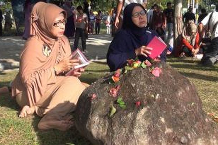 warga membaca Surah Yasin di Komplek Pemakaman Massal Korban Gempa dan Tsunami di Ulhe Lhaeu Banda Aceh. mereka mengenang anggota keluarga yang sudah tiada.